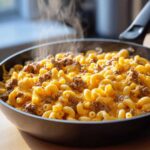 Close-up of hot, steaming Cheesy Ground Beef Pasta Skillet Comfort Food with elbow macaroni and melted cheddar sauce.