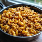 Close-up of Cheesy Taco Pasta One Pot Dinner with elbow macaroni and seasoned ground beef in a black skillet.