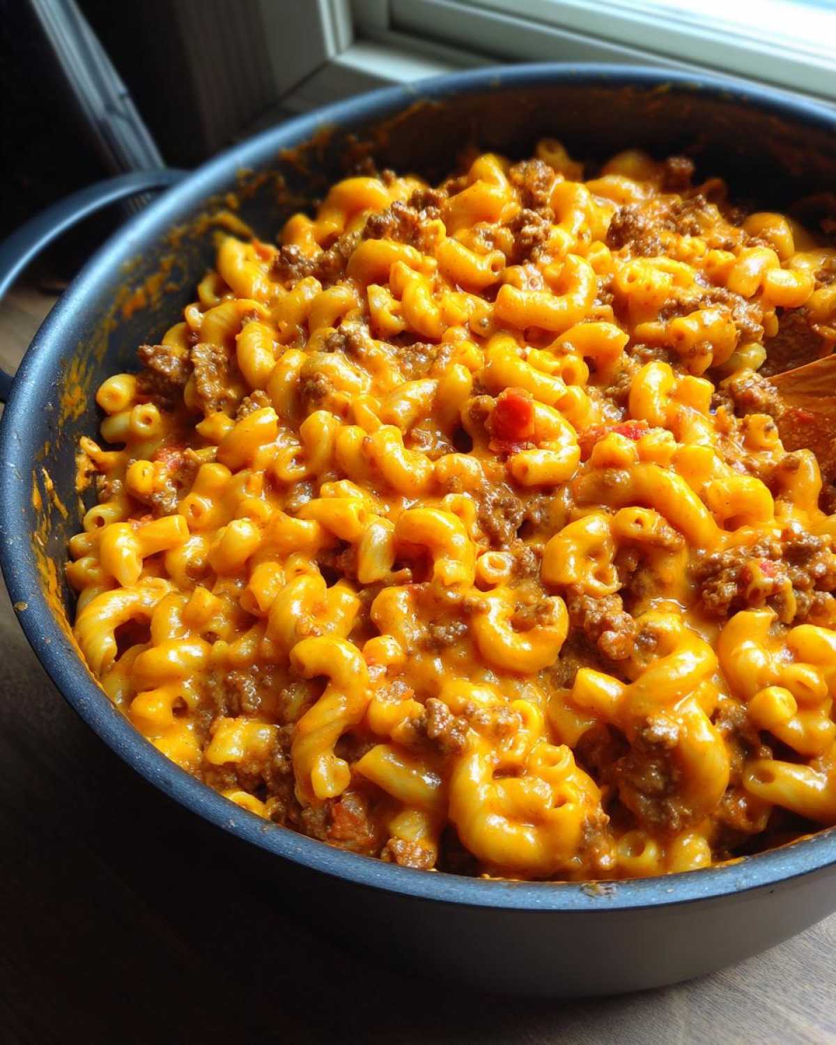 Close-up of Cheesy Taco Pasta One Pot Dinner Idea featuring elbow macaroni mixed with seasoned ground beef and melted orange cheese sauce.
