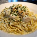 Close-up of Creamy Lemon Chicken Pasta with fettuccine noodles, chunks of chicken, and fresh parsley garnish.