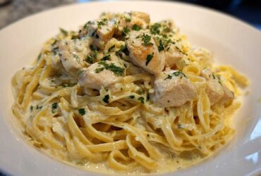 Close-up of Creamy Lemon Chicken Pasta with fettuccine noodles, chunks of chicken, and fresh parsley garnish.