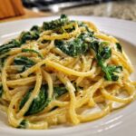 Close-up of a serving of Creamy Lemon Ricotta Pasta with Spinach, coated in a rich sauce and topped with cracked black pepper.