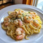 Close-up of Creamy Lemon Shrimp Pasta tossed with fettuccine, topped with shrimp and parsley.