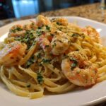 Close-up of Creamy Lemon Shrimp Pasta featuring fettuccine coated in a rich sauce and topped with sautéed shrimp and fresh parsley.