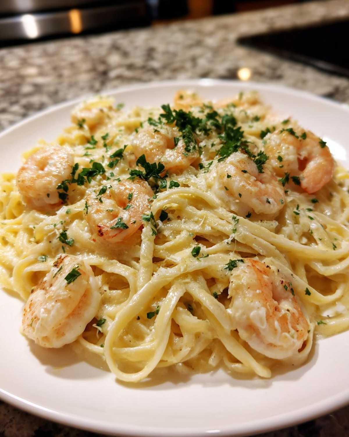 Close-up of Creamy Lemon Shrimp Pasta featuring fettuccine, pink shrimp, and a sprinkle of fresh parsley.