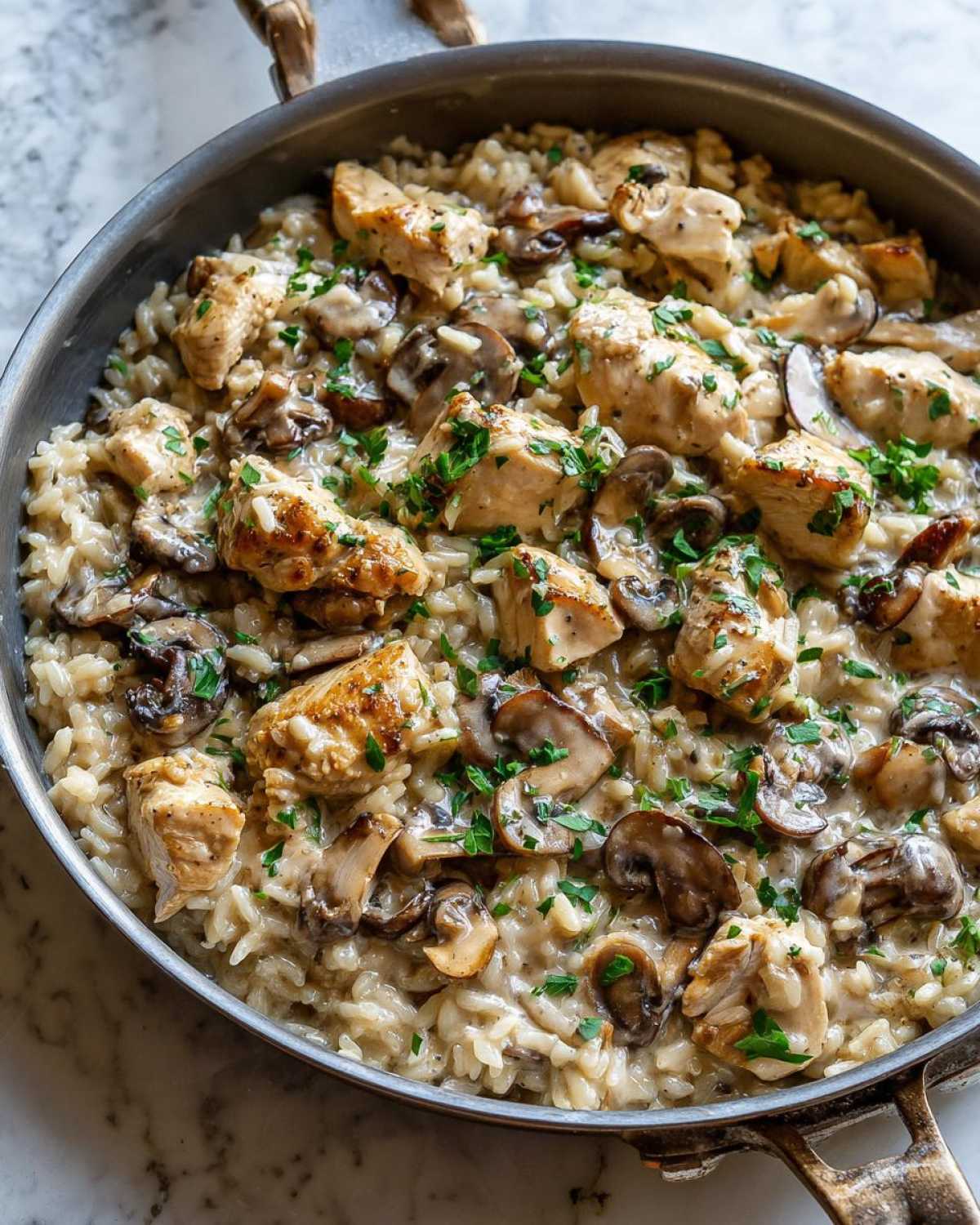 Close-up of Creamy Mushroom Chicken and Rice Skillet, featuring seared chicken pieces and sliced mushrooms in a rich sauce.