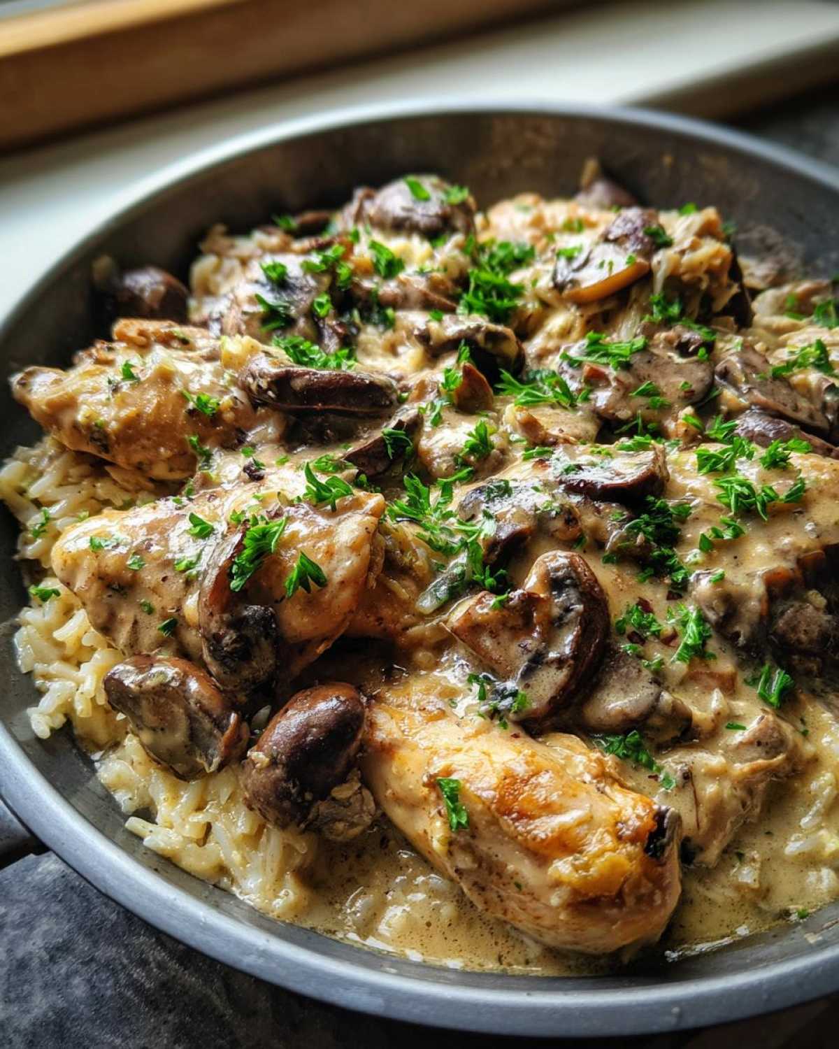 Close-up of Creamy Mushroom Chicken and Rice Skillet with rich sauce and parsley garnish.