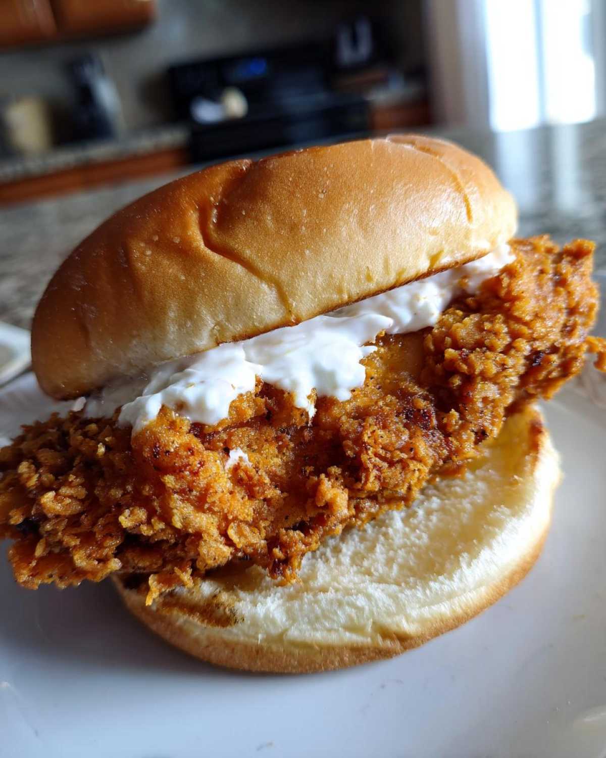 A close-up of a Crispy Chicken Burger with Garlic Mayo, featuring a thick, crunchy fried chicken patty on a soft bun.