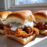 Three delicious Crispy Chicken Sliders with Garlic Sauce stacked on soft buns, featuring crunchy fried chicken.
