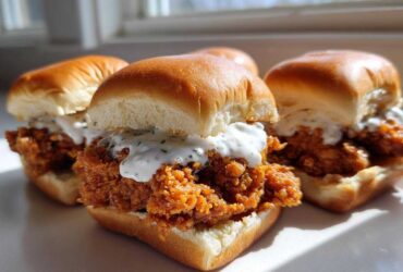Three delicious Crispy Chicken Sliders with Garlic Sauce stacked on soft buns, featuring crunchy fried chicken.