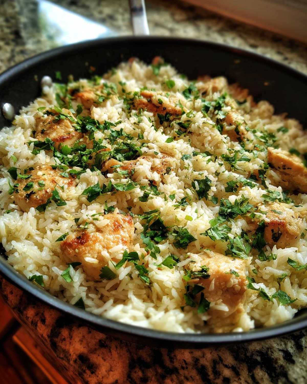 Close-up of Garlic Butter Rice with Chicken Skillet, topped generously with fresh chopped parsley.