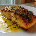 Close-up of a perfectly cooked Garlic Butter Salmon with crispy edges resting in melted garlic butter sauce.