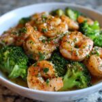 Close-up of Garlic Butter Shrimp and Broccoli Skillet, featuring plump shrimp coated in sauce and fresh parsley, served with bright green broccoli florets.
