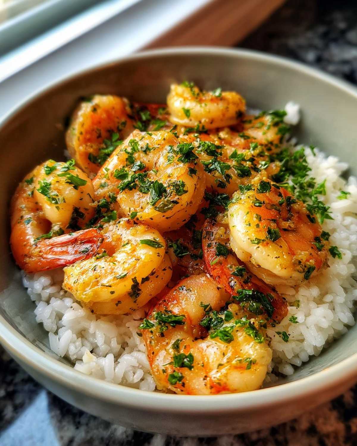 Close-up of a Garlic Butter Shrimp Bowl with Rice, featuring plump, saucy shrimp topped with parsley.