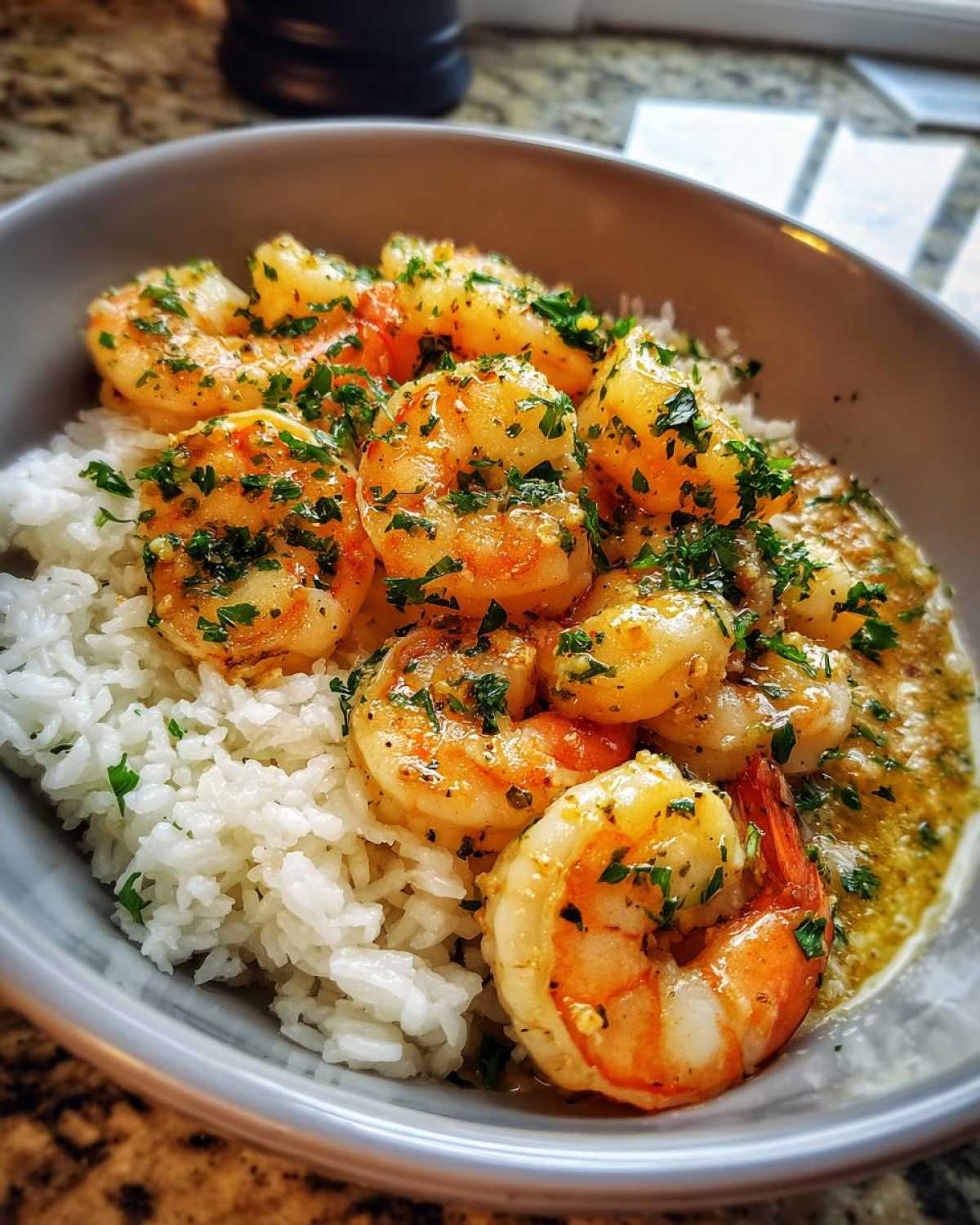Close-up of a Garlic Butter Shrimp Bowl with Rice, featuring plump shrimp coated in garlic butter sauce and parsley over white rice.