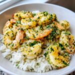 Close-up of a Garlic Butter Shrimp Rice Bowl featuring plump shrimp coated in garlic butter and fresh parsley over white rice.