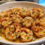Close-up of succulent shrimp coated in garlic butter sauce with herbs and chili flakes from the Garlic Butter Shrimp Skillet.