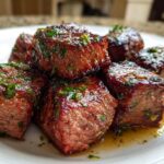 Close-up of seared Garlic Butter Steak Bites topped with fresh parsley, glistening with butter sauce.