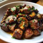 Close-up of savory Garlic Butter Steak Bites with Mushrooms, glistening in sauce and topped with fresh parsley.