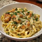 Close-up of Honey Garlic Chicken Pasta with cream sauce, topped with parsley and parmesan.