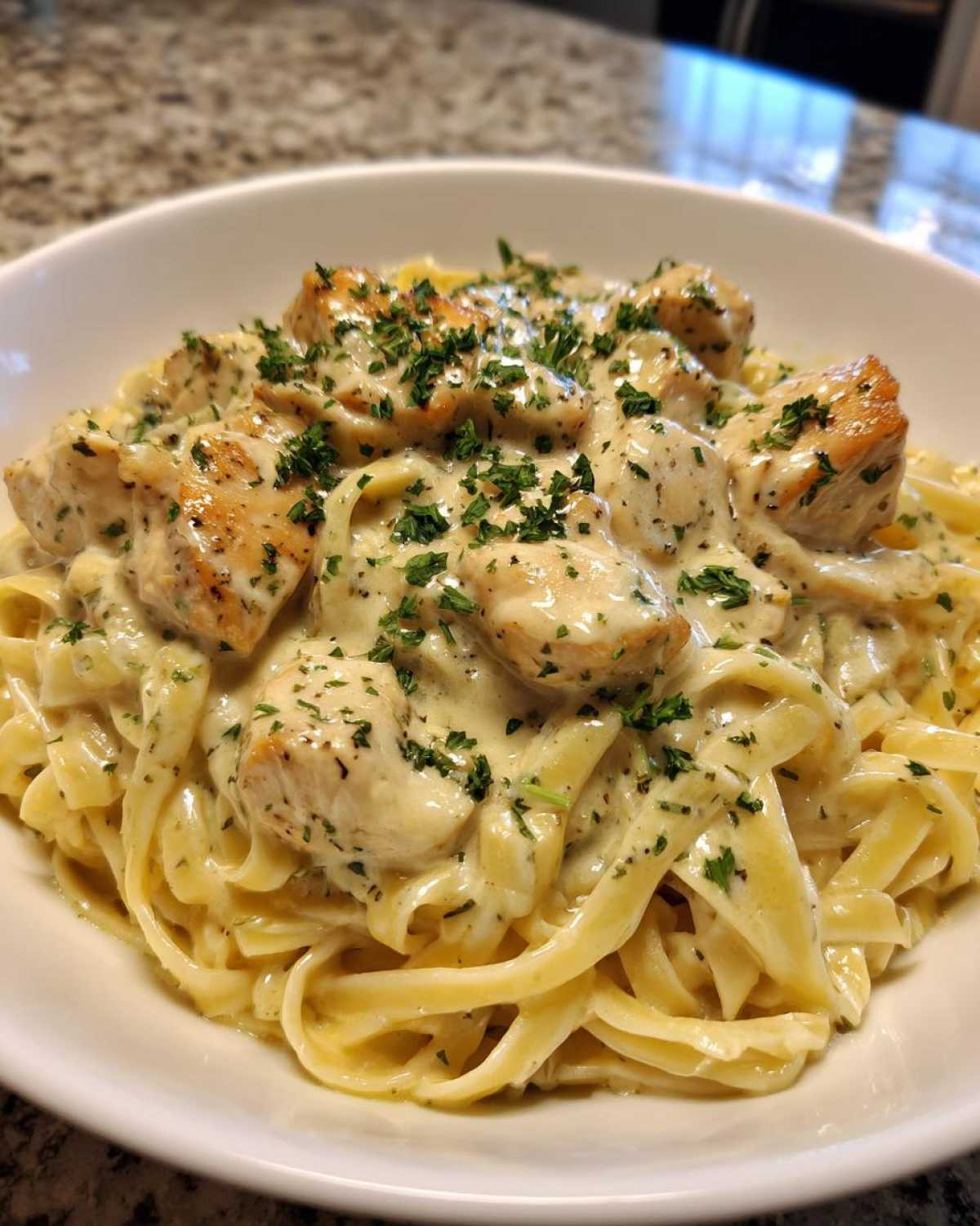 Close-up of Honey Garlic Chicken Pasta with Cream Sauce, featuring fettuccine noodles and topped with parsley.