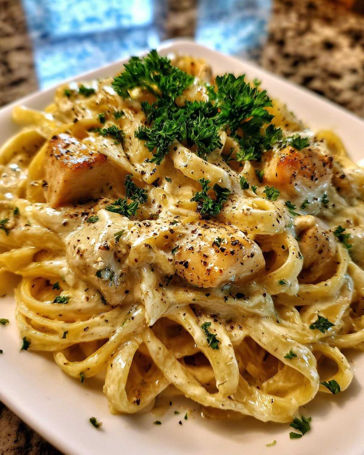 Close-up of Honey Garlic Chicken Pasta with Cream Sauce, topped with fresh parsley and black pepper.