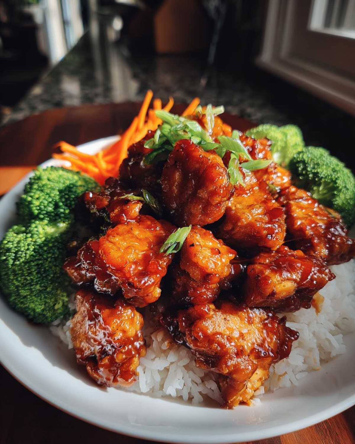 Close-up of a Honey Soy Chicken Bowl Quick Dinner Idea featuring glazed chicken pieces over white rice with broccoli and carrots.