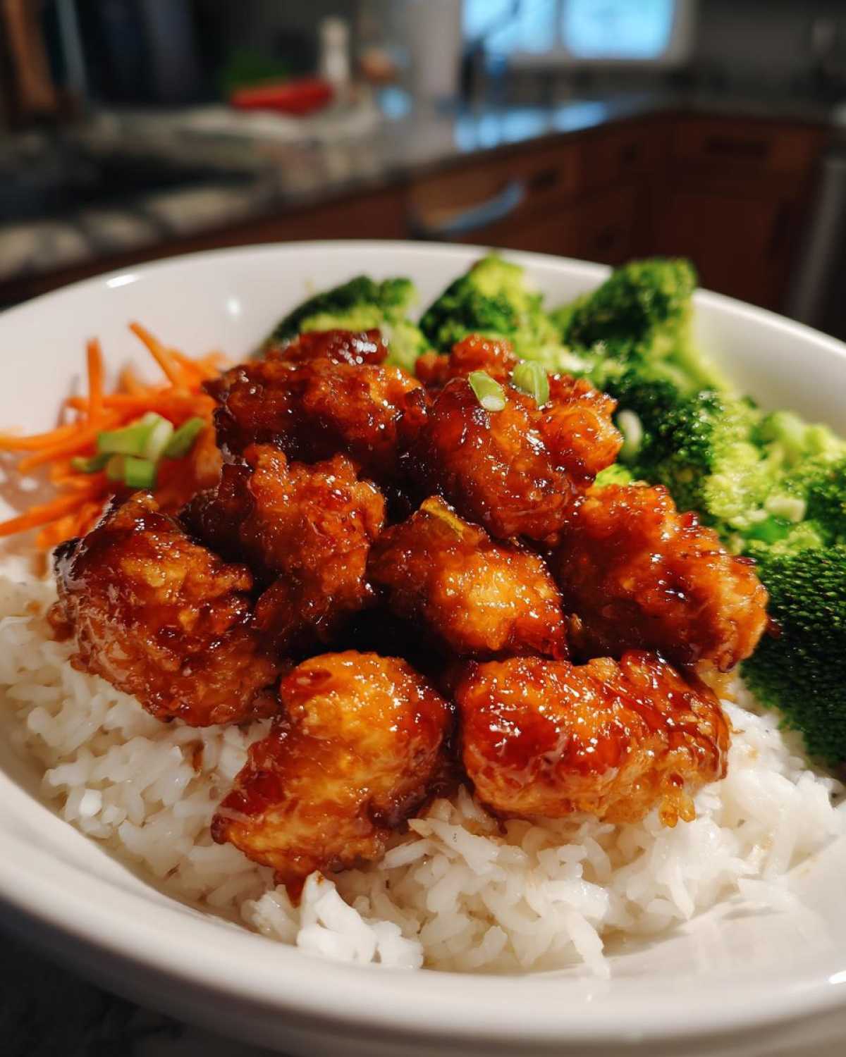 Close-up of a Honey Soy Chicken Bowl Quick Dinner Idea featuring glazed chicken pieces over white rice with broccoli and carrots.