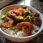 Close-up of a Honey Soy Shrimp Bowl with rice, glazed shrimp, broccoli florets, and sesame seeds.