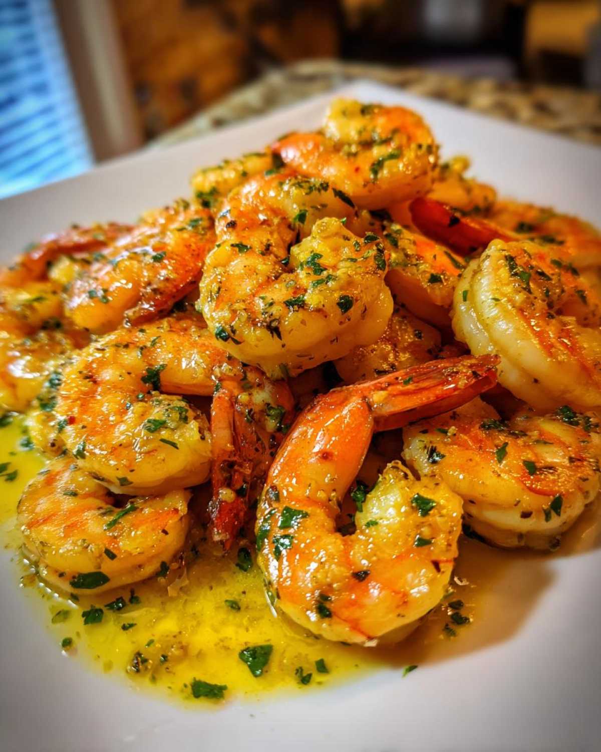 A close-up of cooked shrimp coated in a rich, buttery garlic sauce and sprinkled with parsley, representing Lemon Butter Shrimp with Garlic Flavor.