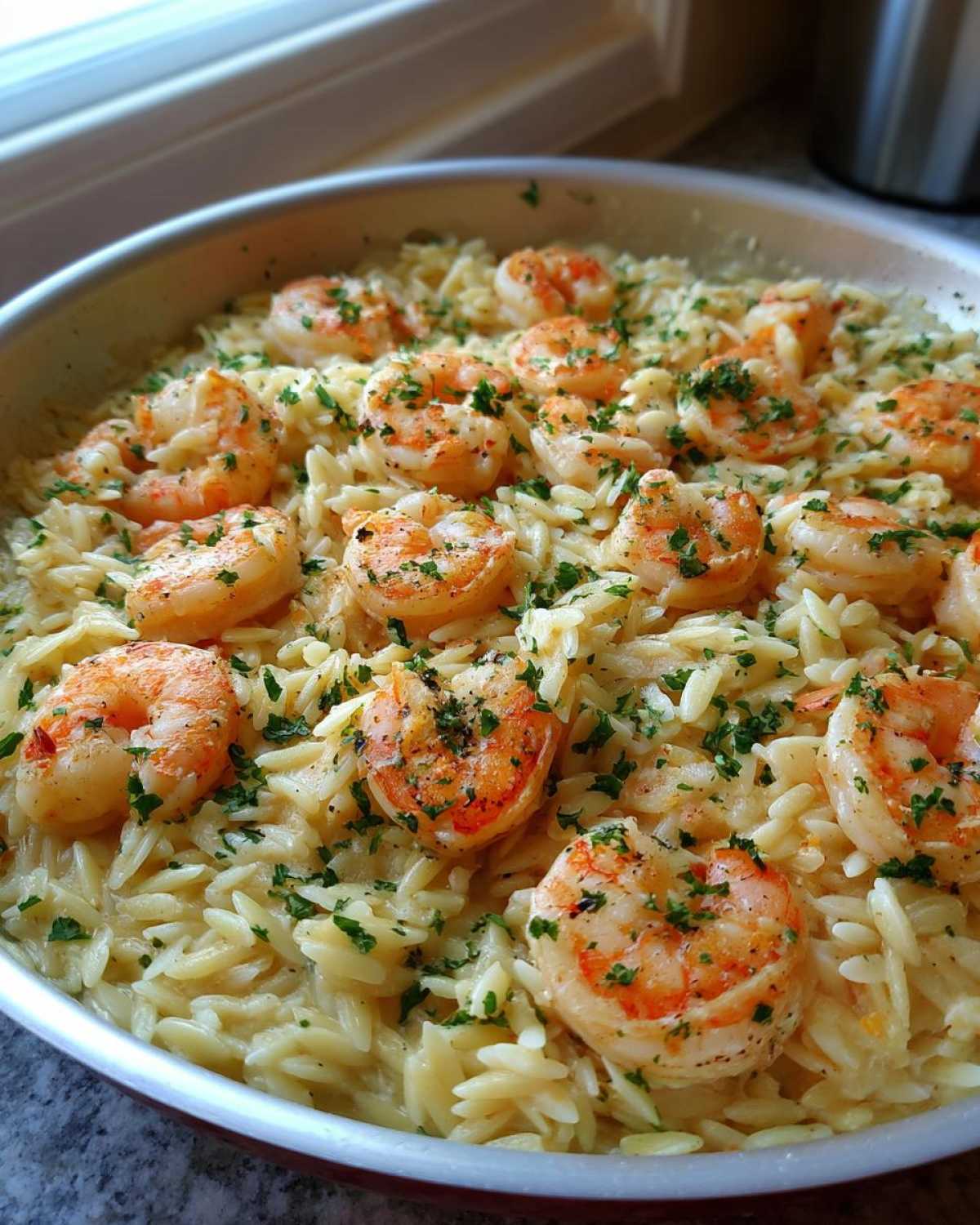 Close-up of a one-pan Lemon Garlic Shrimp Orzo Dinner topped with fresh parsley.