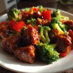 Close-up of Sticky Teriyaki Chicken Stir Fry Quick Meal featuring glazed chicken pieces, bright green broccoli, and red bell peppers.