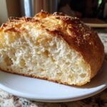 Cross-section view showing the airy crumb structure of homemade Parmesan Garlic Artisan Bread with a golden, crunchy crust.