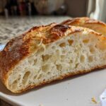 Close-up of the open, airy crumb structure of a slice of Parmesan Garlic Artisan Bread.